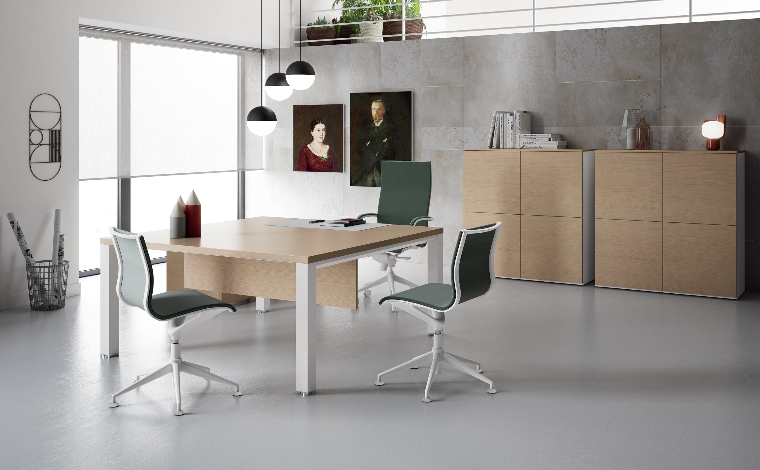 Bureau moderne équipé de la gamme Attitudes Bureaux Tables de réunion Asset - un grand bureau en bois associé à trois chaises vertes, des lampes suspendues, des armoires, des œuvres d'art murales et une plante sur une étagère en hauteur. Les murs clairs et les grandes fenêtres mettent en valeur son design minimal et modulaire.