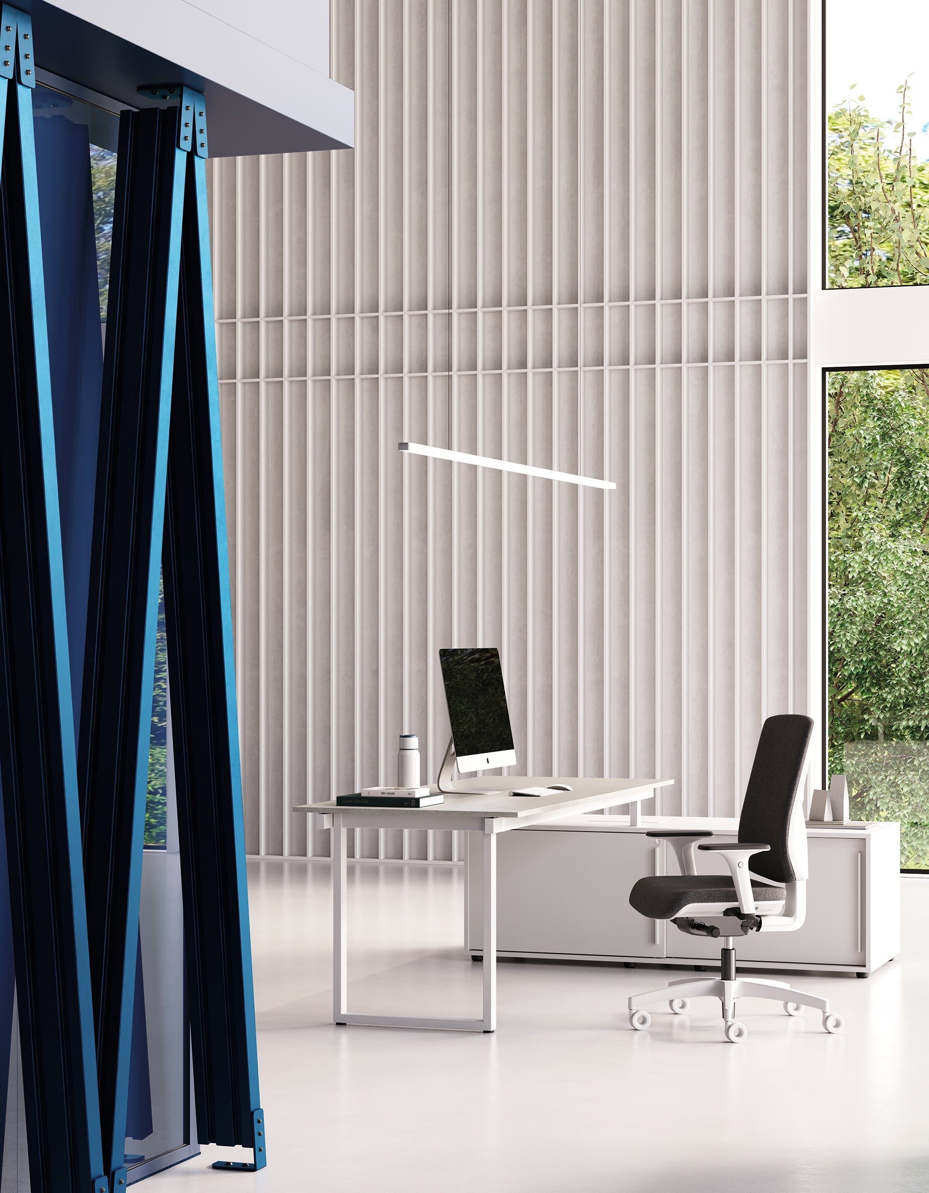 Un bureau moderne et minimaliste présente le Bureau BE.1 de Progetto CMR, un ordinateur, une chaise noire et une grande fenêtre avec de la verdure. Les panneaux muraux verticaux et les lignes épurées créent un espace de travail flexible dans les bureaux contemporains.