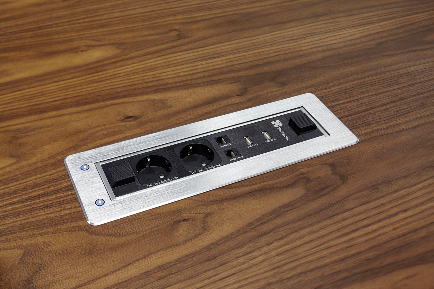 La table Claudio Bellini Tables de réunion Dr est dotée d'un panneau encastré avec deux prises électriques, deux ports USB et deux ports Ethernet dans le plateau en bois, accentué par une bordure métallique argentée - idéal pour les espaces de réunion modernes.
