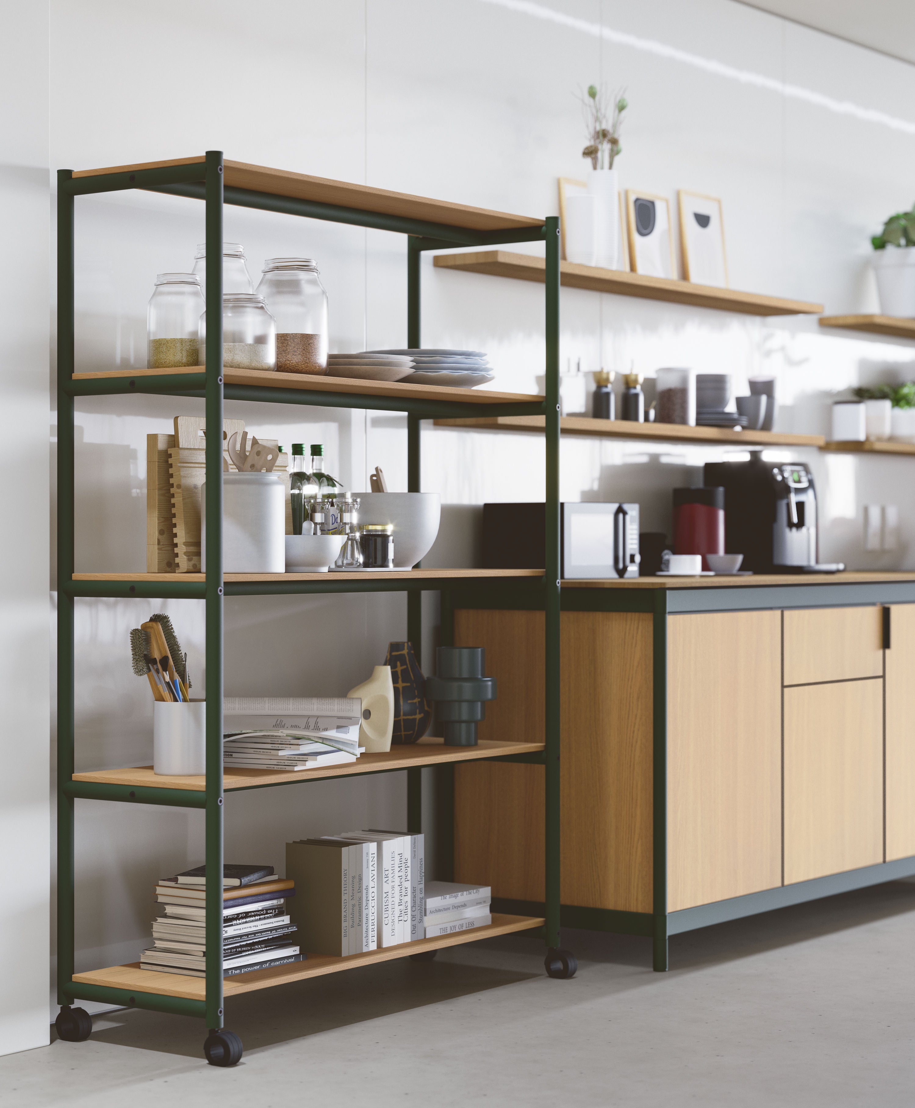 La kitchenette Fluido® d'Attitudes Bureaux offre un espace moderne avec des armoires en bois, des étagères ouvertes et un meuble roulant en métal et bois pour les livres, les bocaux, les coupes et les plantes. Une machine à café et des tasses sont posées sur le plan de travail à proximité.