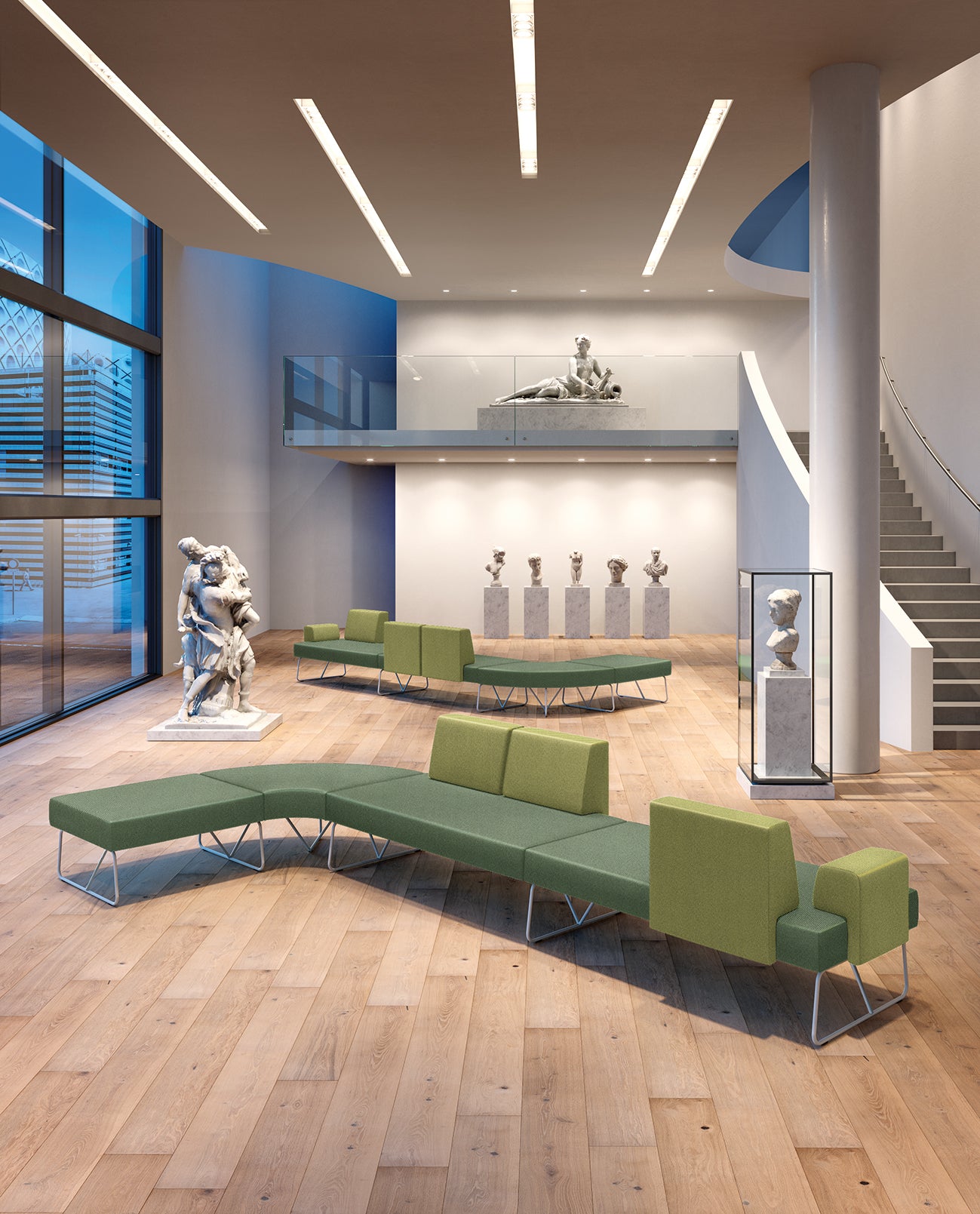 Une galerie d'art moderne avec de grandes fenêtres, des planchers en bois, des sièges d.FLUX Canapés d'accueil Fedra en vert, des sculptures classiques et un escalier incurvé menant à un niveau supérieur où sont exposées d'autres œuvres d'art.