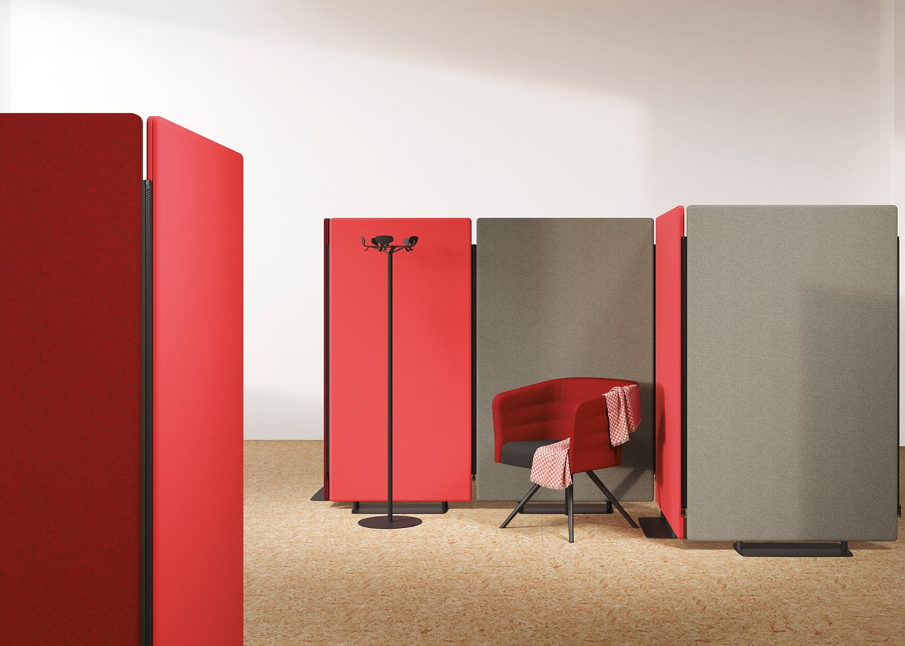 Un bureau moderne est équipé des cloisons et écrans acoustiques MADISON d'Attitudes Bureaux en rouge et gris, d'une chaise rembourrée rouge assortie, d'un porte-manteau noir et d'un tissu à carreaux sur la chaise, le tout sur un sol en bois clair.