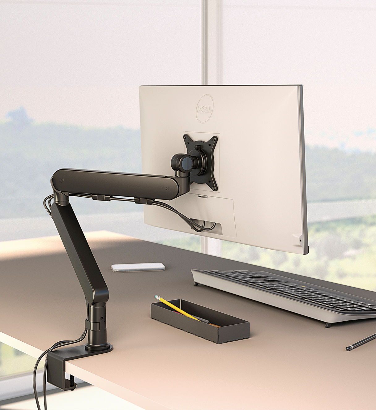 Un écran d'ordinateur est monté sur un bras Attitudes Bureaux Supports écrans Plug et Play Duo, créant ainsi un espace de travail ergonomique. Sur le bureau se trouvent un clavier, un smartphone et un plateau noir contenant un crayon jaune et un stylo. Une fenêtre à la vue floue se trouve derrière.