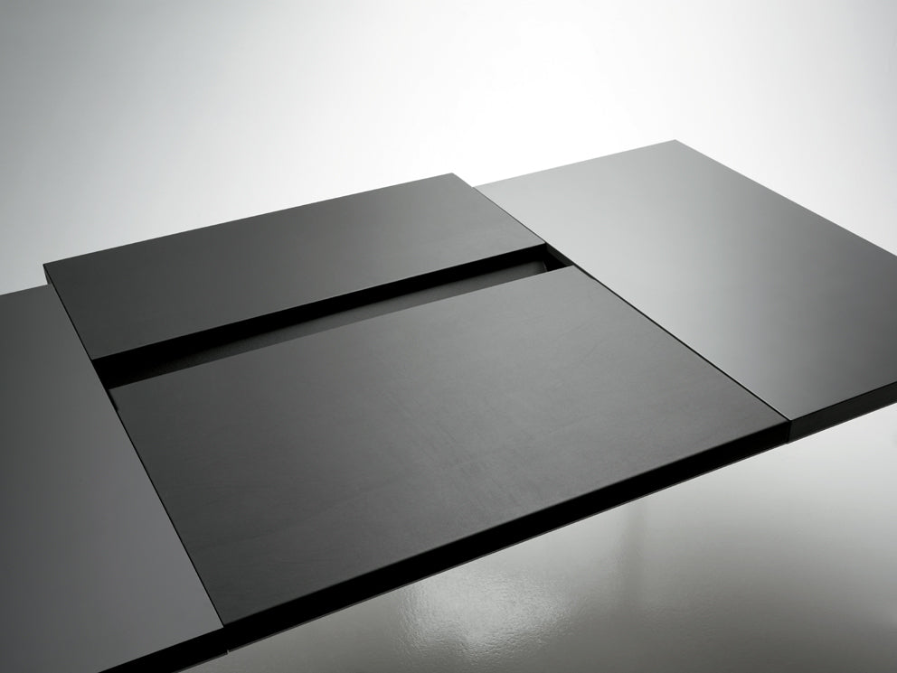 La Neta Executive d'Attitudes Bureaux est une table de salle à manger extensible noire minimaliste avec des feuilles rectangulaires et un panneau d'extension central, parfaite pour les espaces de travail modernes avec des finitions nobles et un design épuré et contemporain.