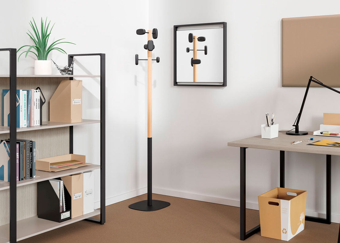 Coin de bureau moderne avec le Portemanteau SHERWOOD d'Emmanuel Gallina, un miroir carré qui le reflète, une étagère avec des boîtes et des livres, une plante en pot, un bureau avec une lampe, et une boîte en carton sur le sol pour une touche zen.