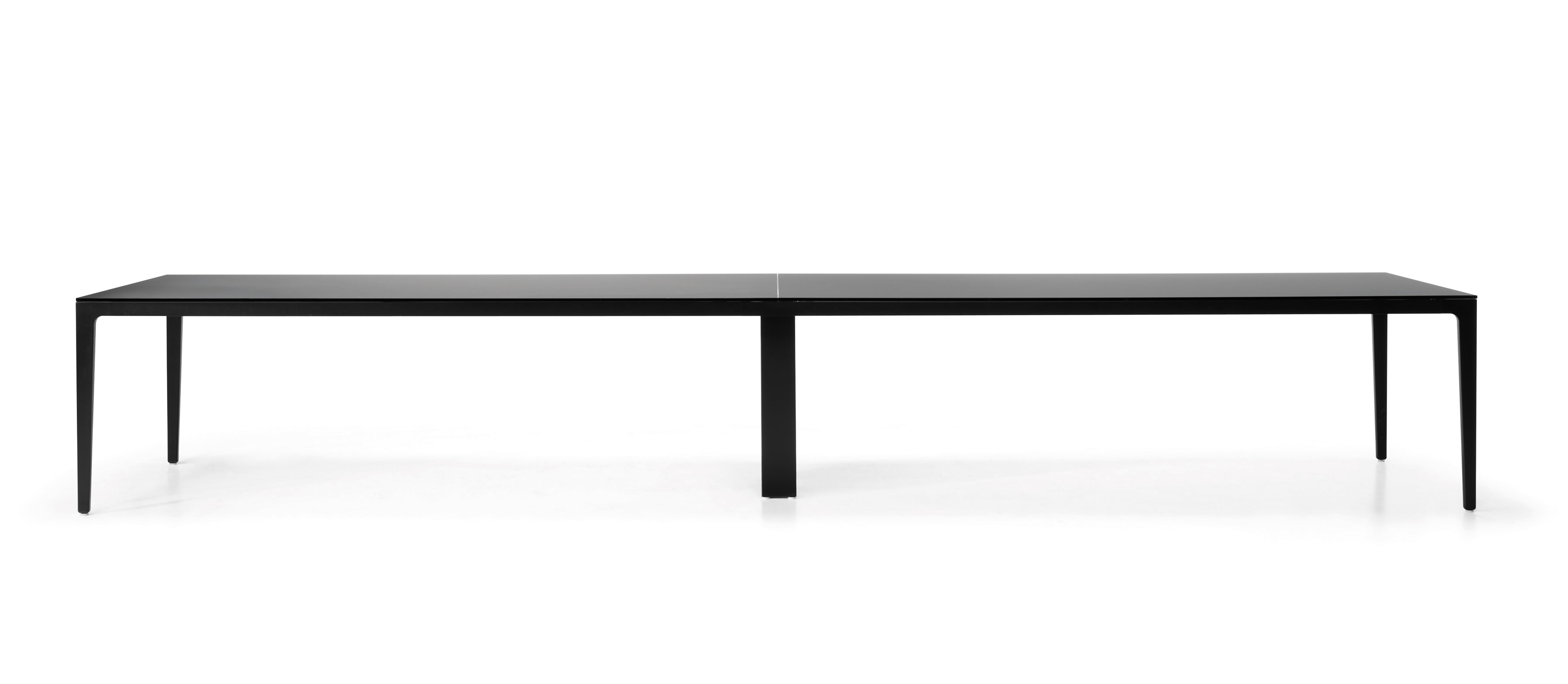 La table de réunion modulables Alplus de Marco Zito est une table rectangulaire noire minimaliste dotée de quatre pieds fins et d'un système de gestion des câbles intégré, présentée sur un fond blanc uni.