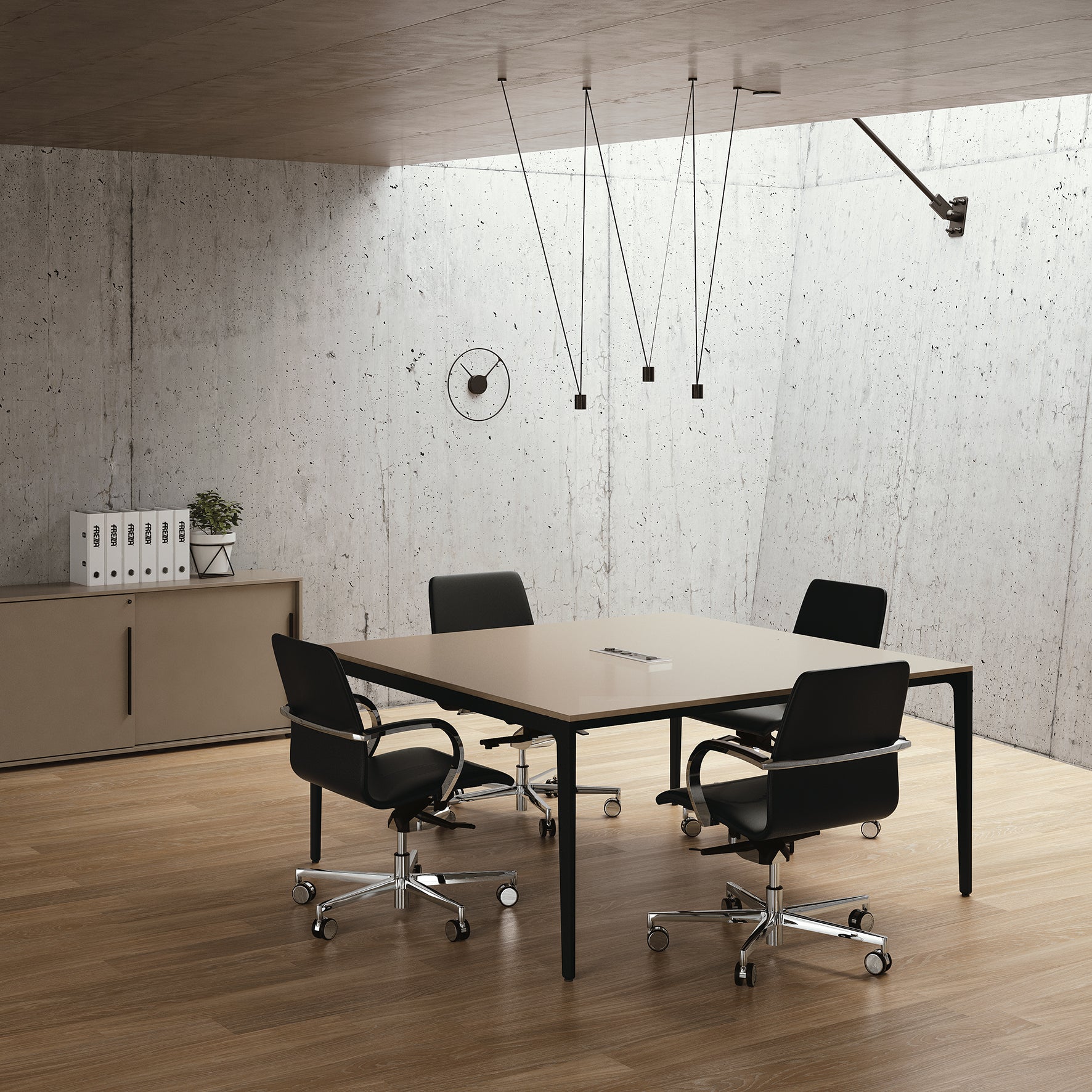 Une salle de réunion moderne et minimaliste avec une table carrée, quatre chaises noires, une horloge murale, des lampes suspendues, un mur en béton, une crédence avec des classeurs et des plantes, un sol en bois et les tables de réunion modulables Alplus de Marco Zito pour des solutions flexibles.