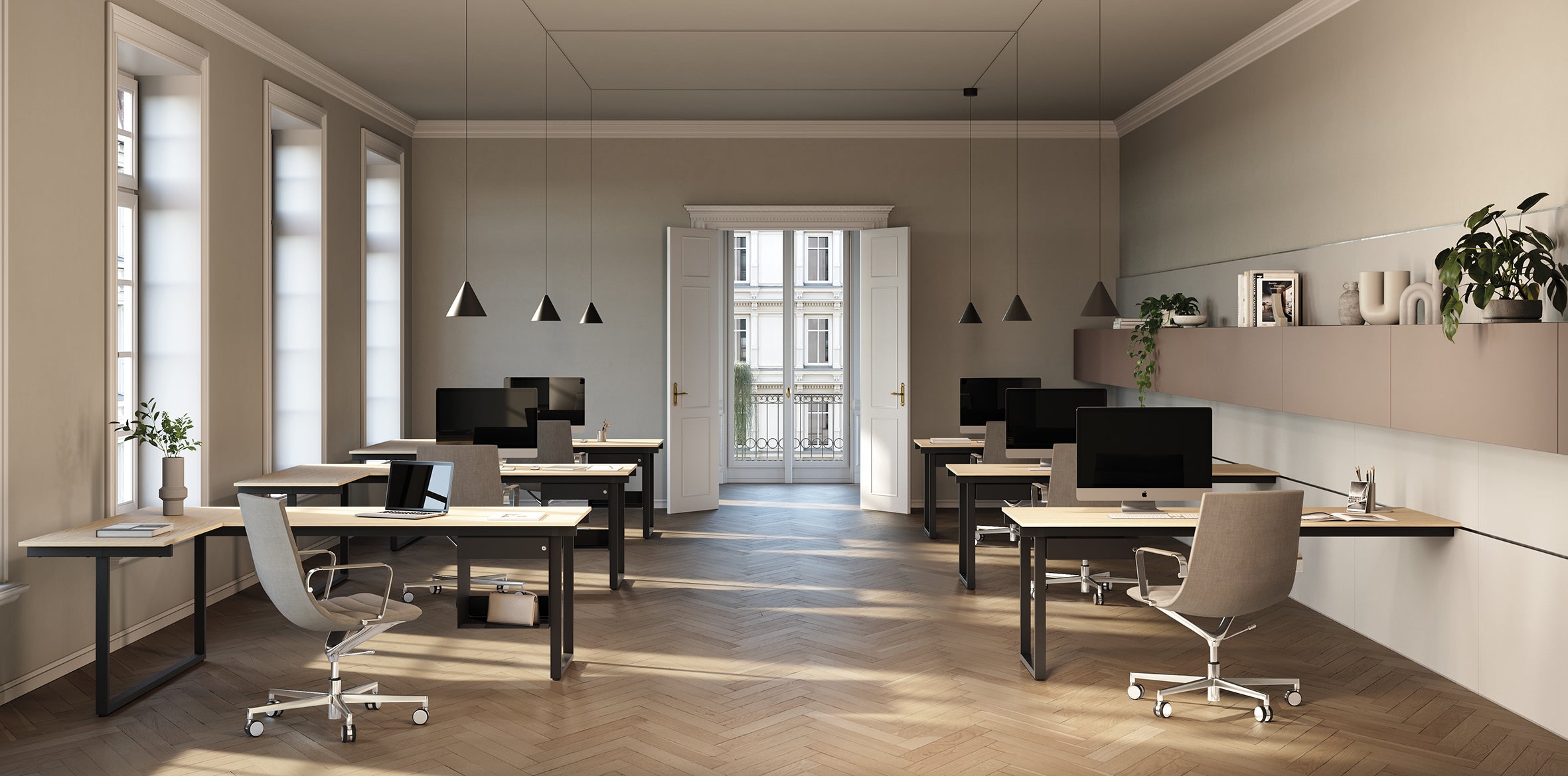 Le bureau moderne comprend six bureaux Bureau BE.1 de Progetto CMR, des ordinateurs et des chaises bien rangés. De grandes fenêtres et des doubles portes ouvertes inondent l'espace de lumière naturelle. Le décor minimaliste comprend des plantes, des étagères murales et des lampes suspendues.