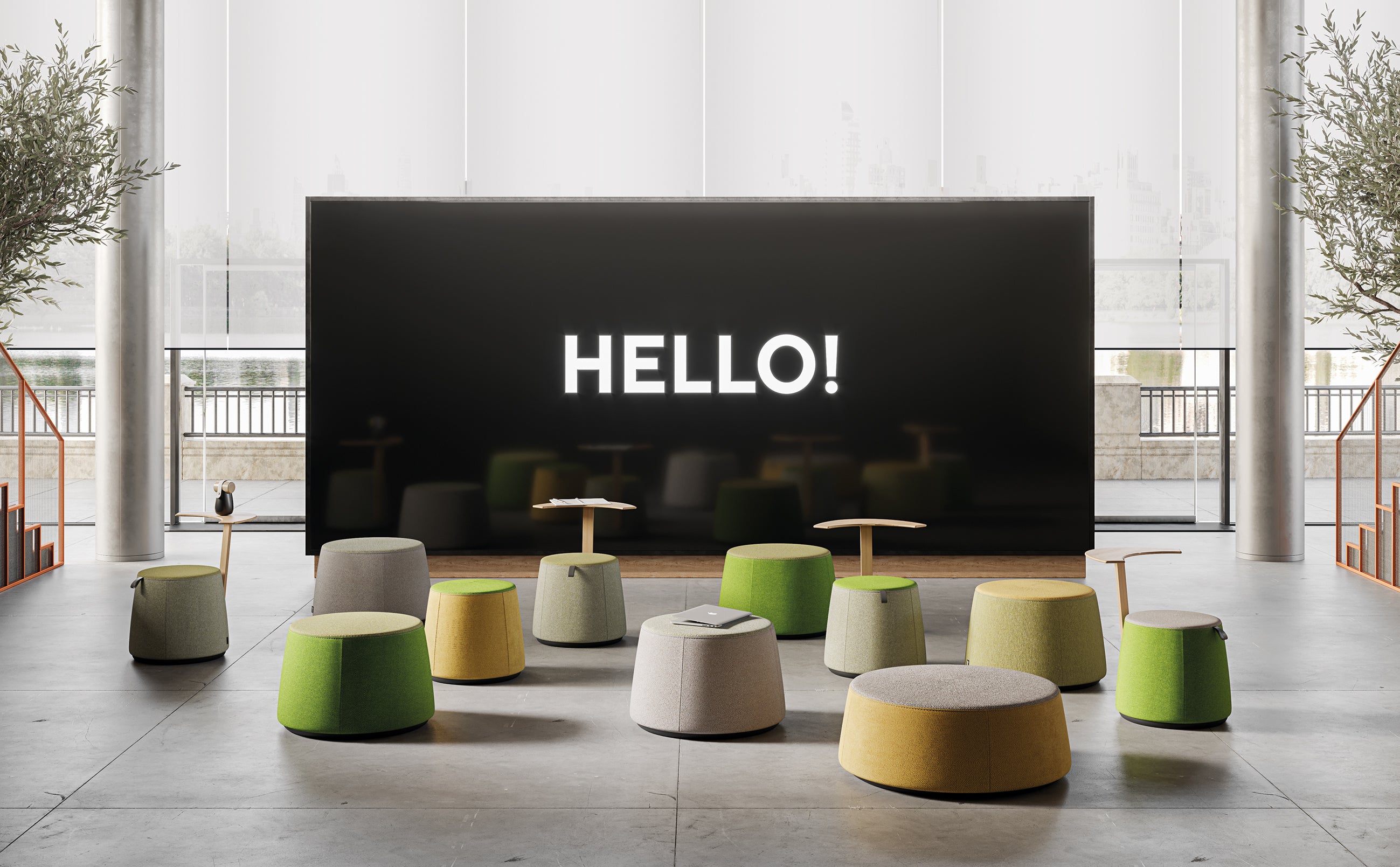 Espace moderne et ouvert présentant la collection Giorgio Topan de poufs design avec table intégrée C1.8, des sièges modulaires colorés avec tables intégrées disposés devant un grand écran noir "HELLO !" et de hautes fenêtres apportant de la lumière naturelle.