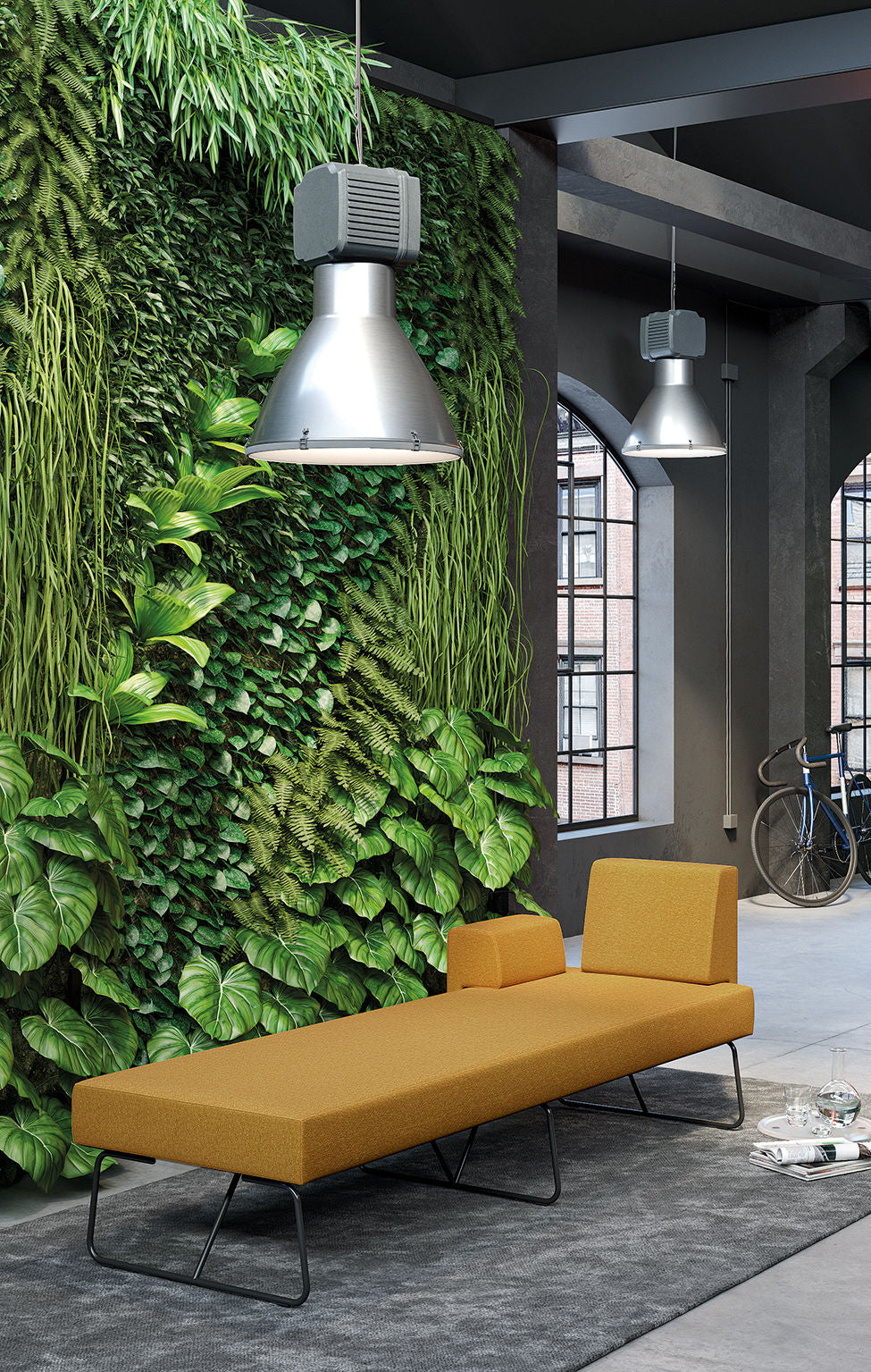 Un intérieur moderne avec un jardin vertical verdoyant, un d.FLUX Canapés d'accueil Fedra en jaune moutarde pour la banquette, de grandes lampes industrielles suspendues, des fenêtres cintrées et un vélo en arrière-plan.