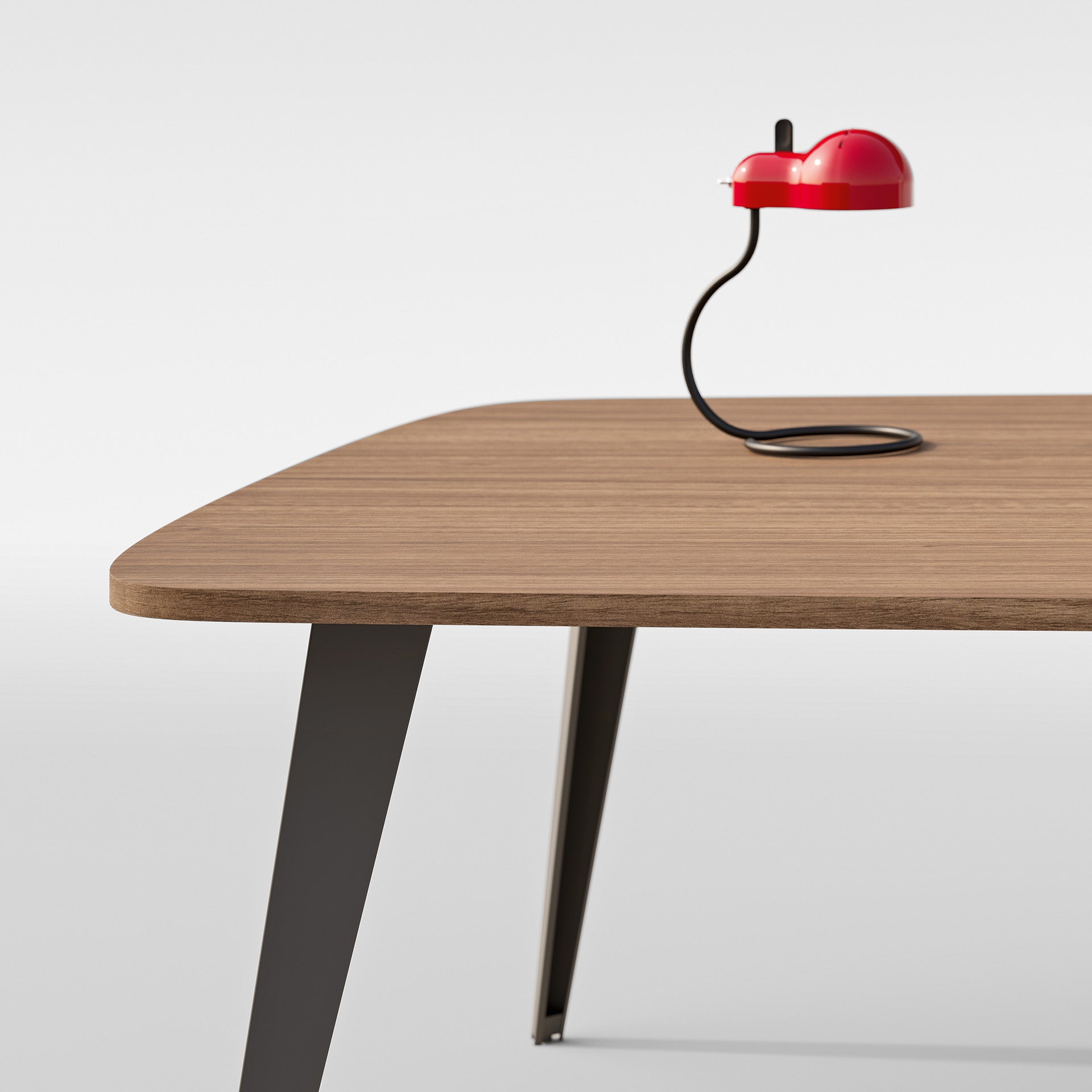 Le Mobilier de direction Pigreco d'Attitudes Bureaux est une table minimaliste en bois avec des pieds métalliques inclinés, associée à une lampe rouge moderne sur une tige noire incurvée, parfaite pour les salles de réunion et placée sur un fond blanc uni.