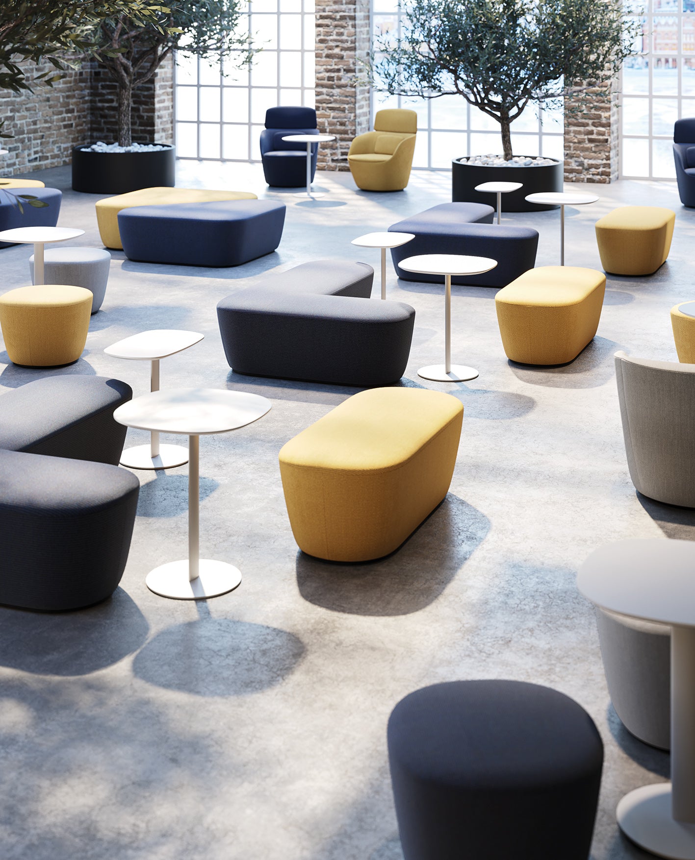 Un salon spacieux et moderne est doté d'ottomans arrondis jaunes et gris, de Claesson Koivisto Rune CKR Tables basses Radar, d'une table d'appoint blanche, de grandes fenêtres, de murs en briques apparentes et d'arbres en pot pour une atmosphère lumineuse et accueillante.