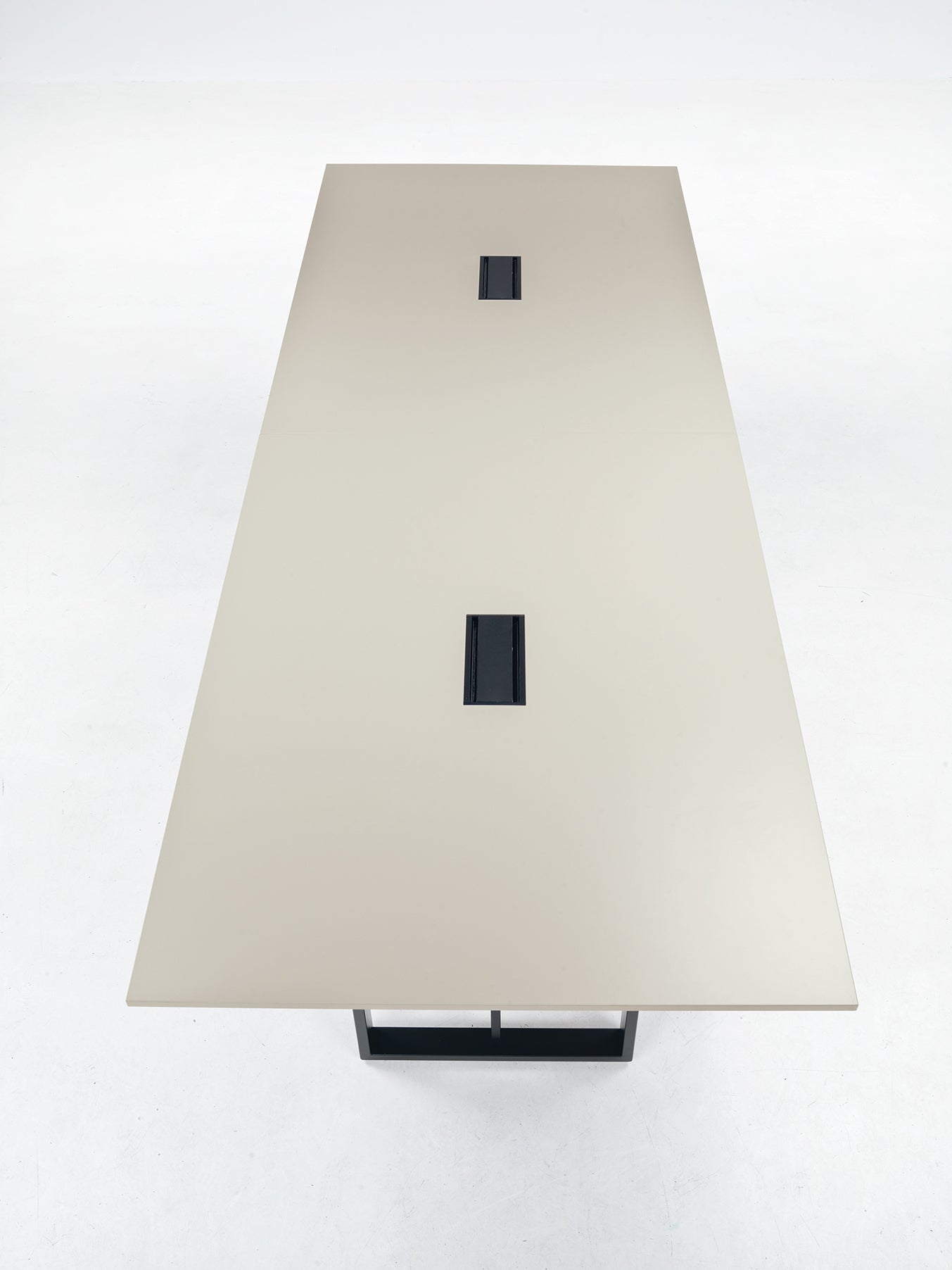 La table de réunion rectangulaire beige Velvet d'Attitudes Bureaux, avec deux fentes centrales pour les câbles et connectivité intégrée, est idéale pour les grandes salles de réunion et présentée sur fond blanc.