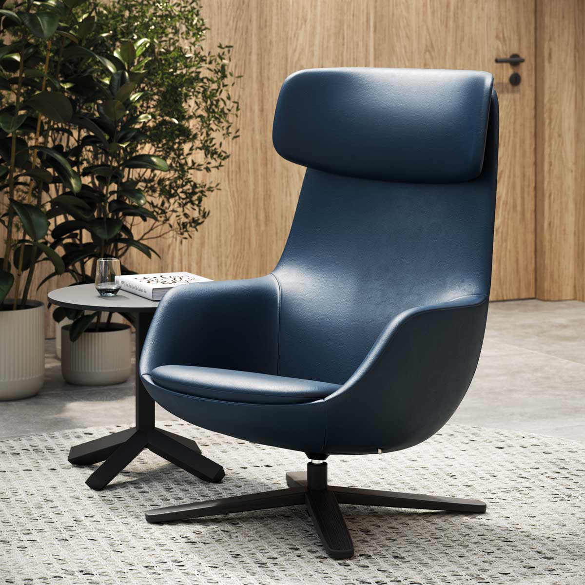 Le fauteuil bleu Radar design de Claesson Koivisto Rune CKR, doté d'un dossier haut, est posé sur un tapis texturé à côté d'une petite table ronde, avec des plantes en pot et un mur en bois en arrière-plan.