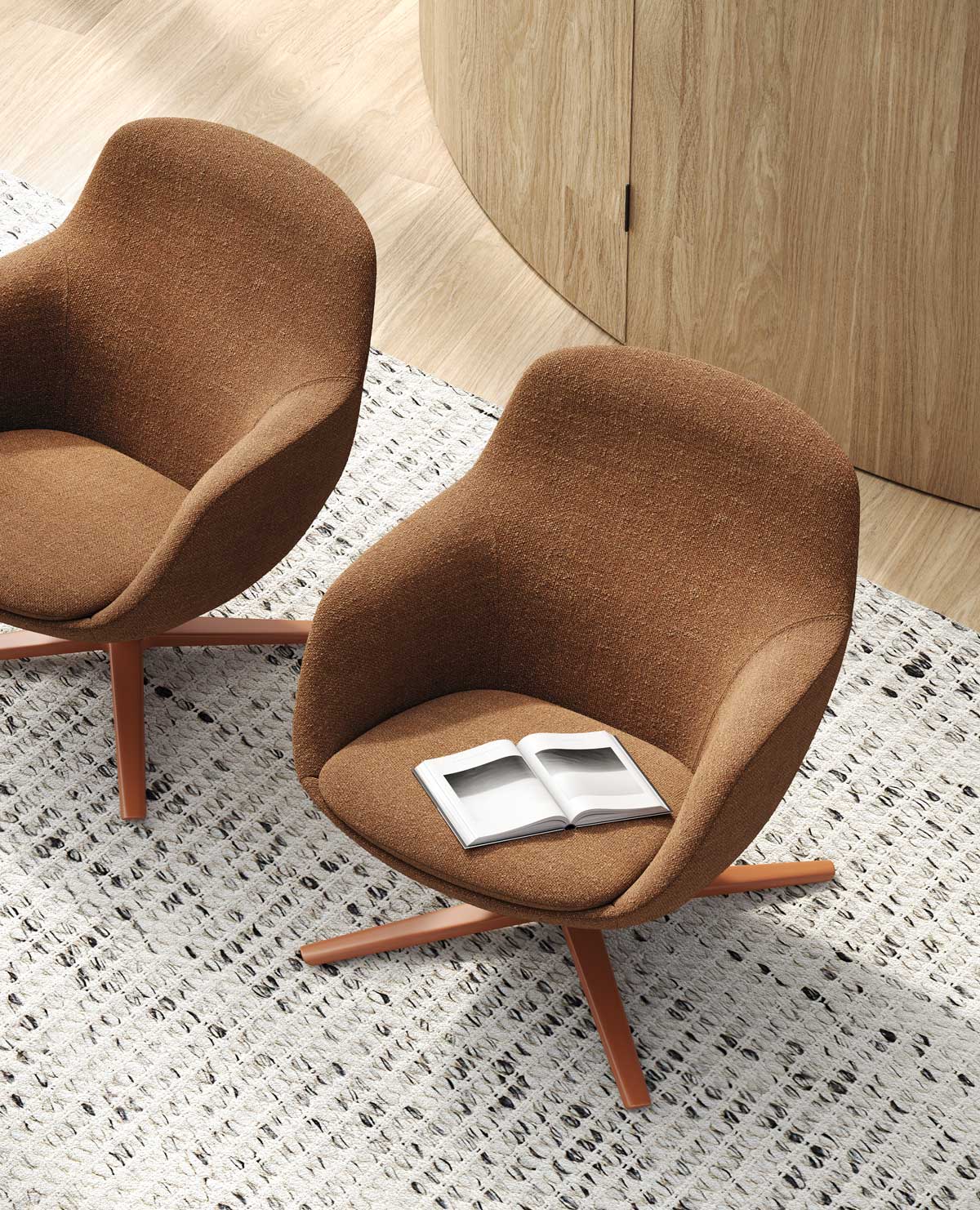 Deux Fauteuils design Radar de Claesson Koivisto Rune CKR sont posés sur un tapis texturé blanc et gris. Un livre ouvert est posé sur une chaise longue sculpturale, sur un sol en bois clair et des panneaux de bois incurvés.